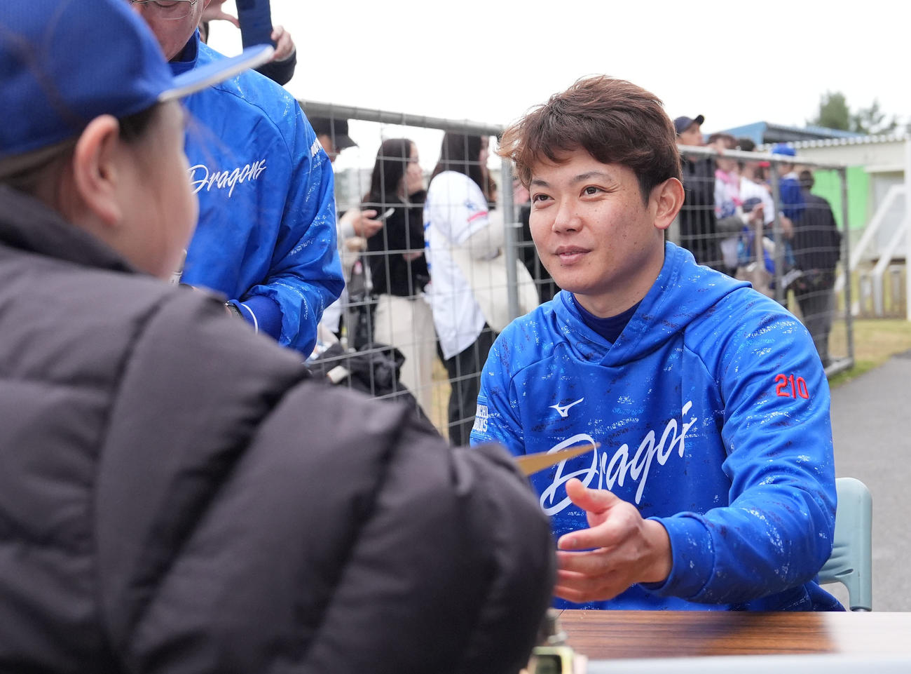 練習終了後、詰めかけたファンにサイン会を行う岡田（右）（撮影・森本幸一）