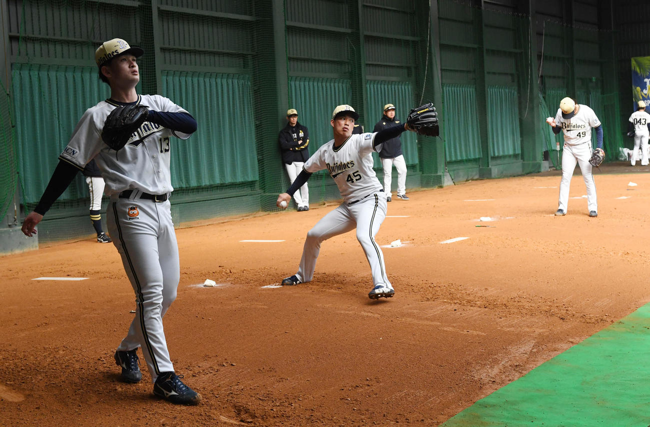 ブルペンで投球練習を行うルーキー、左から寺西、東山、片山を見る岸田監督（奥）（撮影・前岡正明）