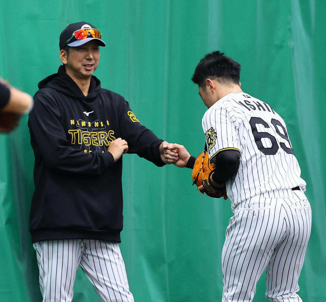 投球練習を終えた石井（右）とグータッチを交わす藤川監督（撮影・藤尾明華）