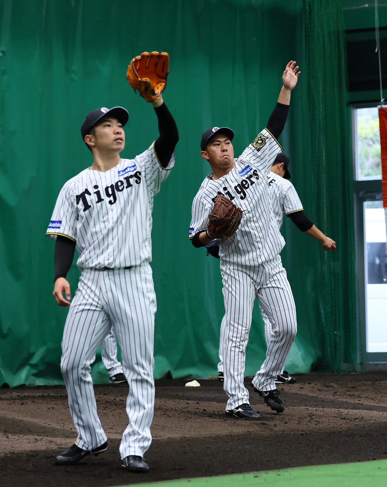 ブルペンで投球練習をする石井（左）と桐敷（撮影・藤尾明華）