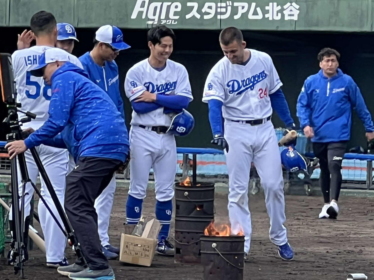寒さをしのぐためドラム缶でのたき火に手をかざすジェイソン・ボスラー外野手（マリナーズ）ら中日ナイン（2025年2月4日）