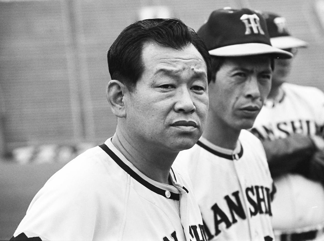 77年、厳しい表情をみせる吉田義男監督、右は一枝修平コーチ