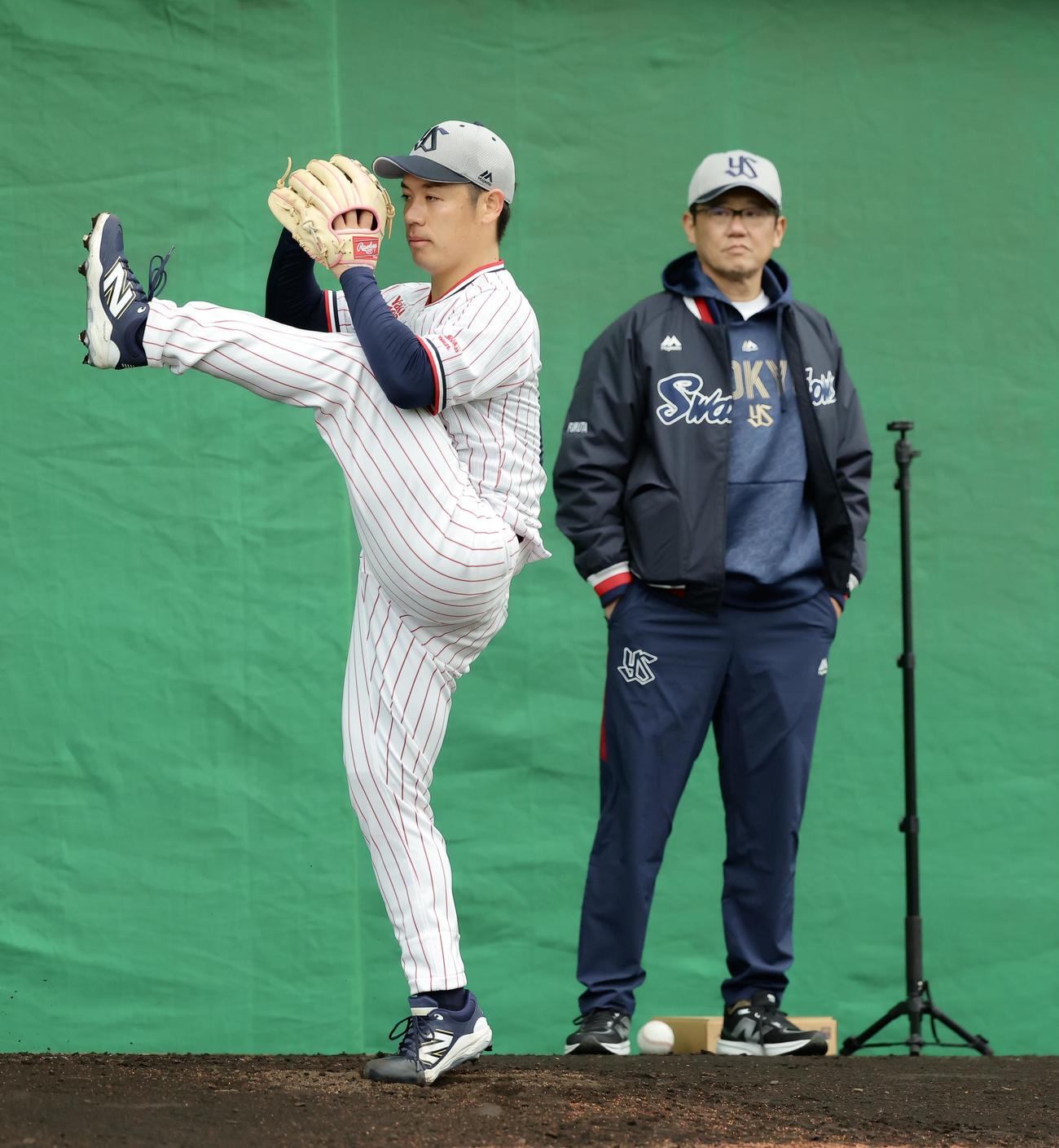 ブルペンでヤクルト小川（左）の投球フォームを見つめる古田氏（撮影・河田真司）