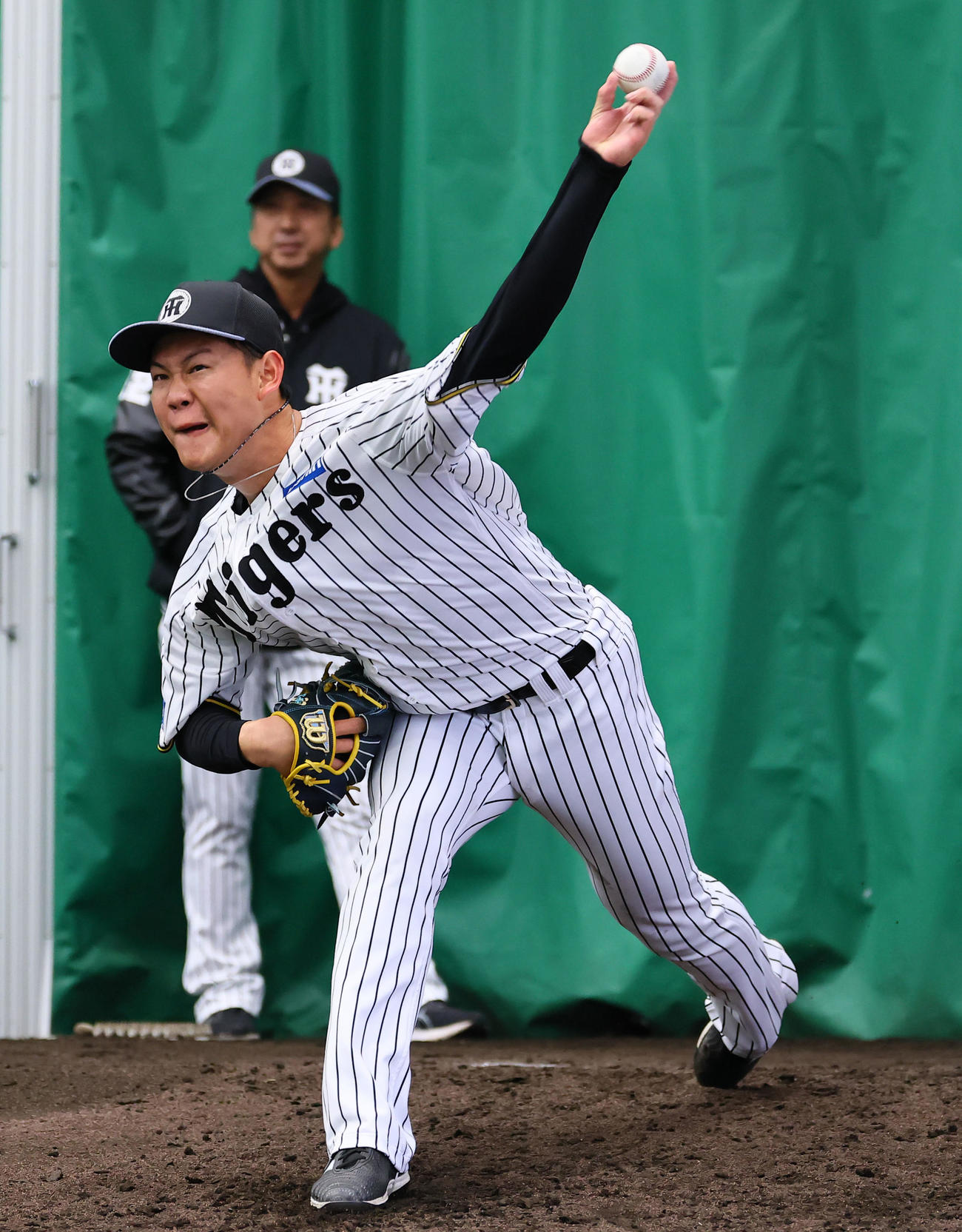 藤川監督（右）が見つめる中、ブルペンで投げ込む及川（撮影・藤尾明華）