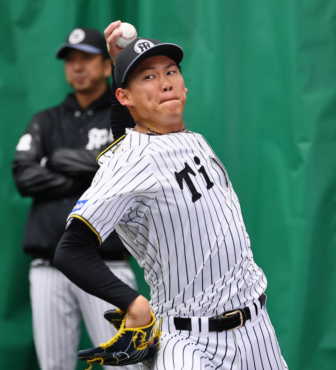 藤川監督（右）が見つめる中、ブルペンで投げ込む及川（撮影・藤尾明華）