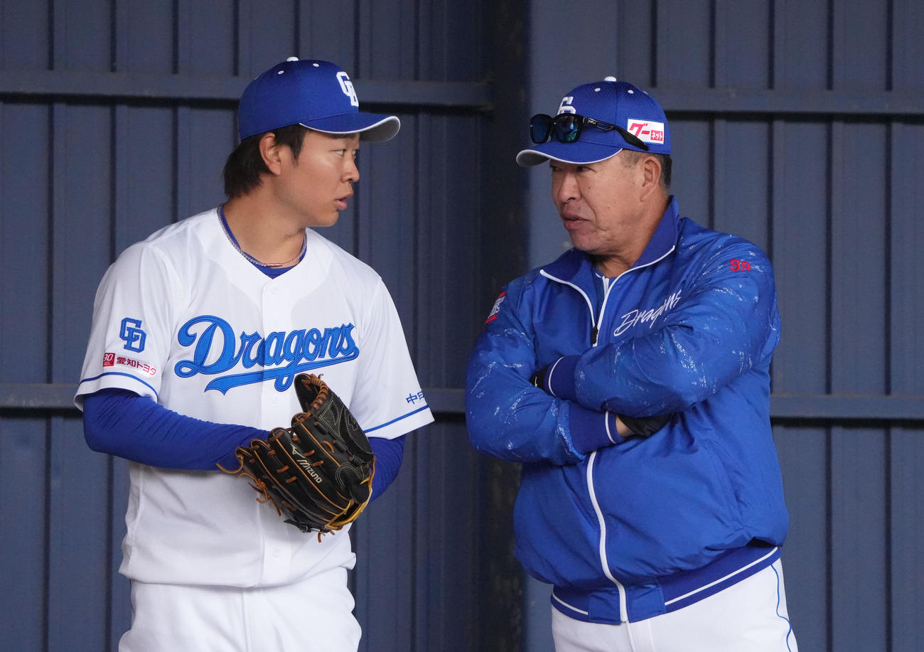 ブルペンで投球練習の合間に井上監督（右）と言葉を交わす高橋宏（撮影・森本幸一）