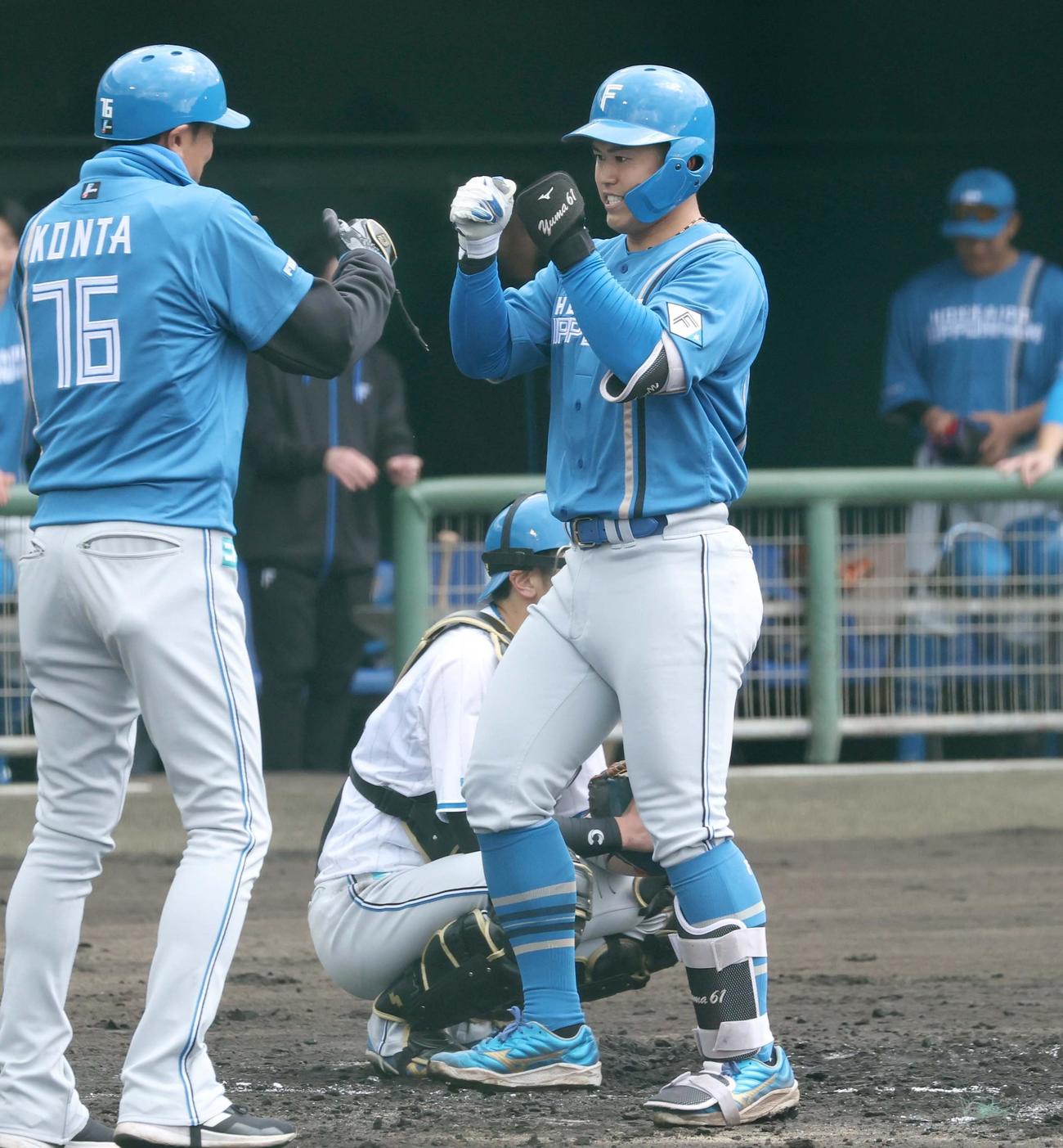 日本ハム紅白戦　3回に左越え本塁打を放ち紺田コーチとタッチする今川（撮影・黒川智章）