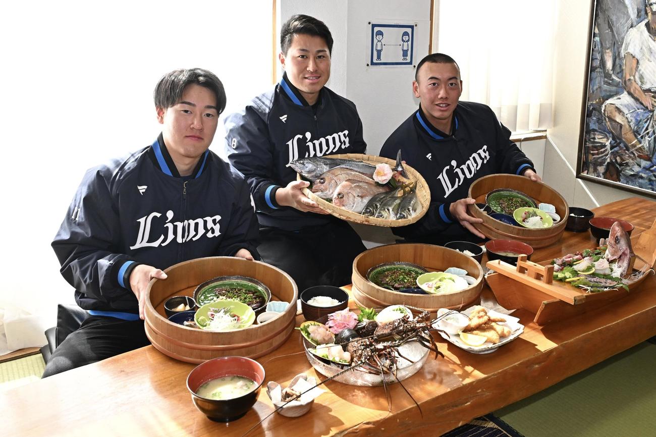 名物の海産物料理を前に写真に納まる西武の、左から上田、渡部聖、村田（撮影・滝沢徹郎）