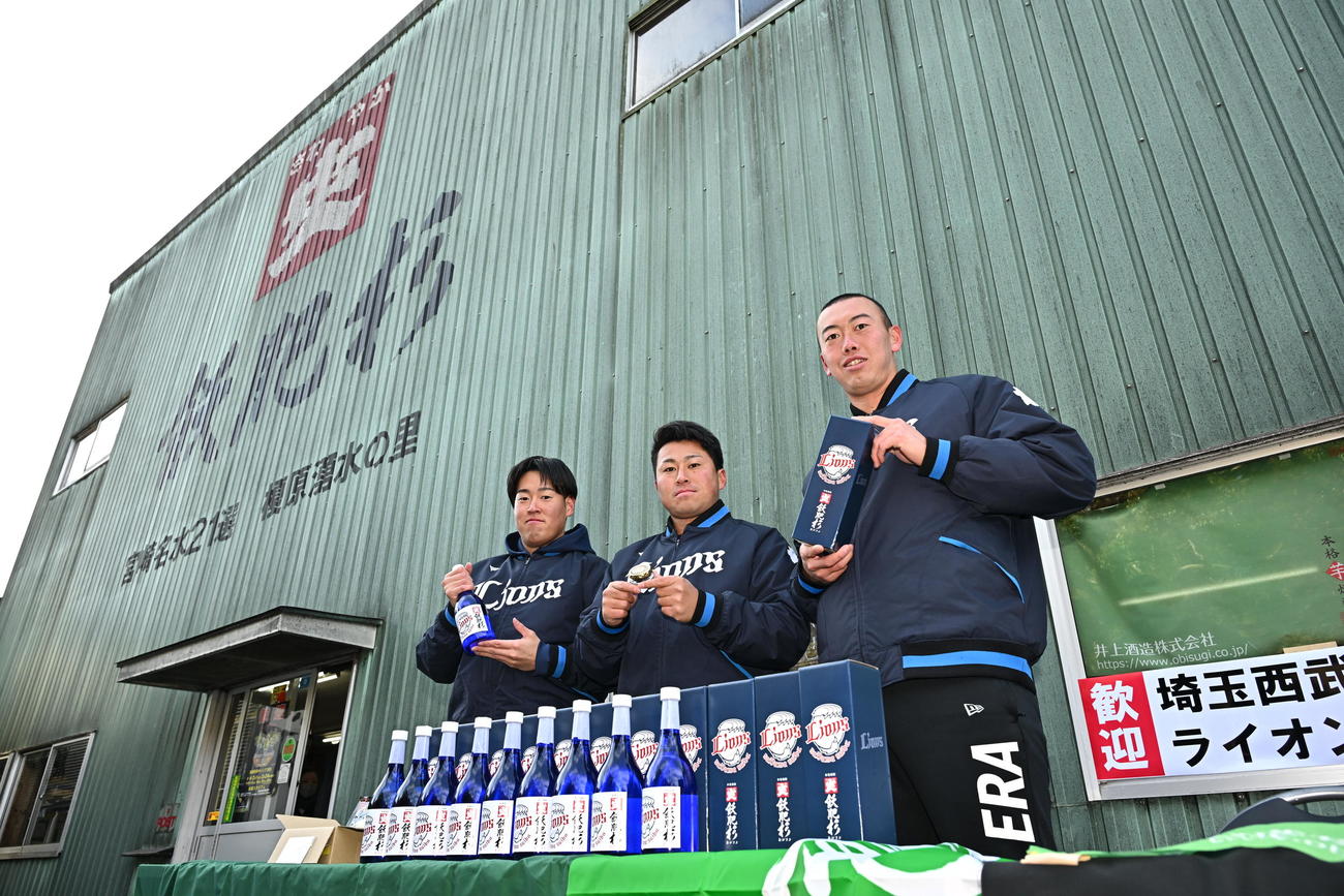 休日に井上酒造を訪れ記念のお酒を手に写真に納まる西武の、左から上田、渡部聖、村田＝2025年2月5日