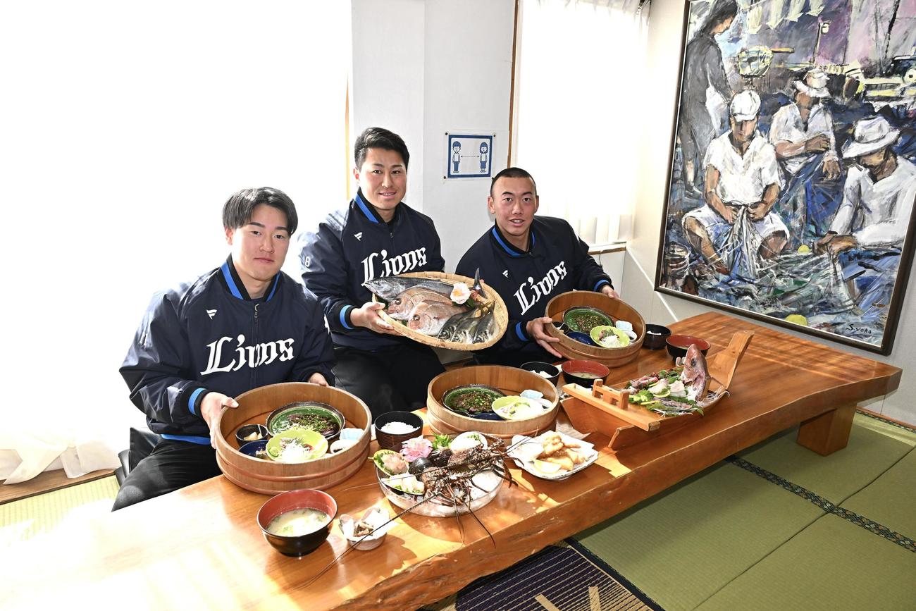 名物の海産物料理を前に写真に納まる西武の、左から上田、渡部聖、村田（撮影・滝沢徹郎）