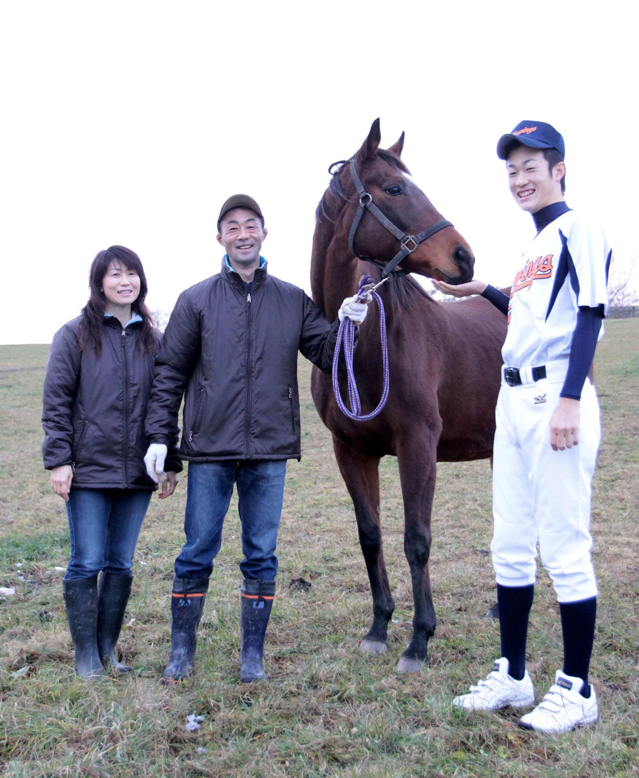 2010年、ダイシンオレンジの母アシヤマダムを囲み、笑顔を見せる戸川さん夫妻と長男大輔氏（右）