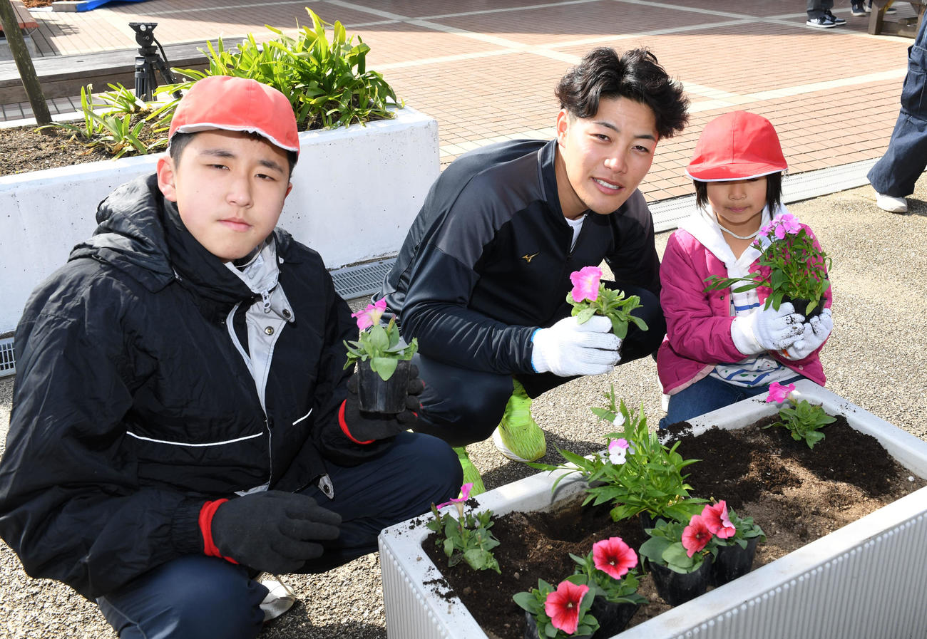 キャンプ休日を利用して「道の駅フェニックス」を訪れた麦谷は内海小の児童と植樹を行う（撮影・前岡正明）