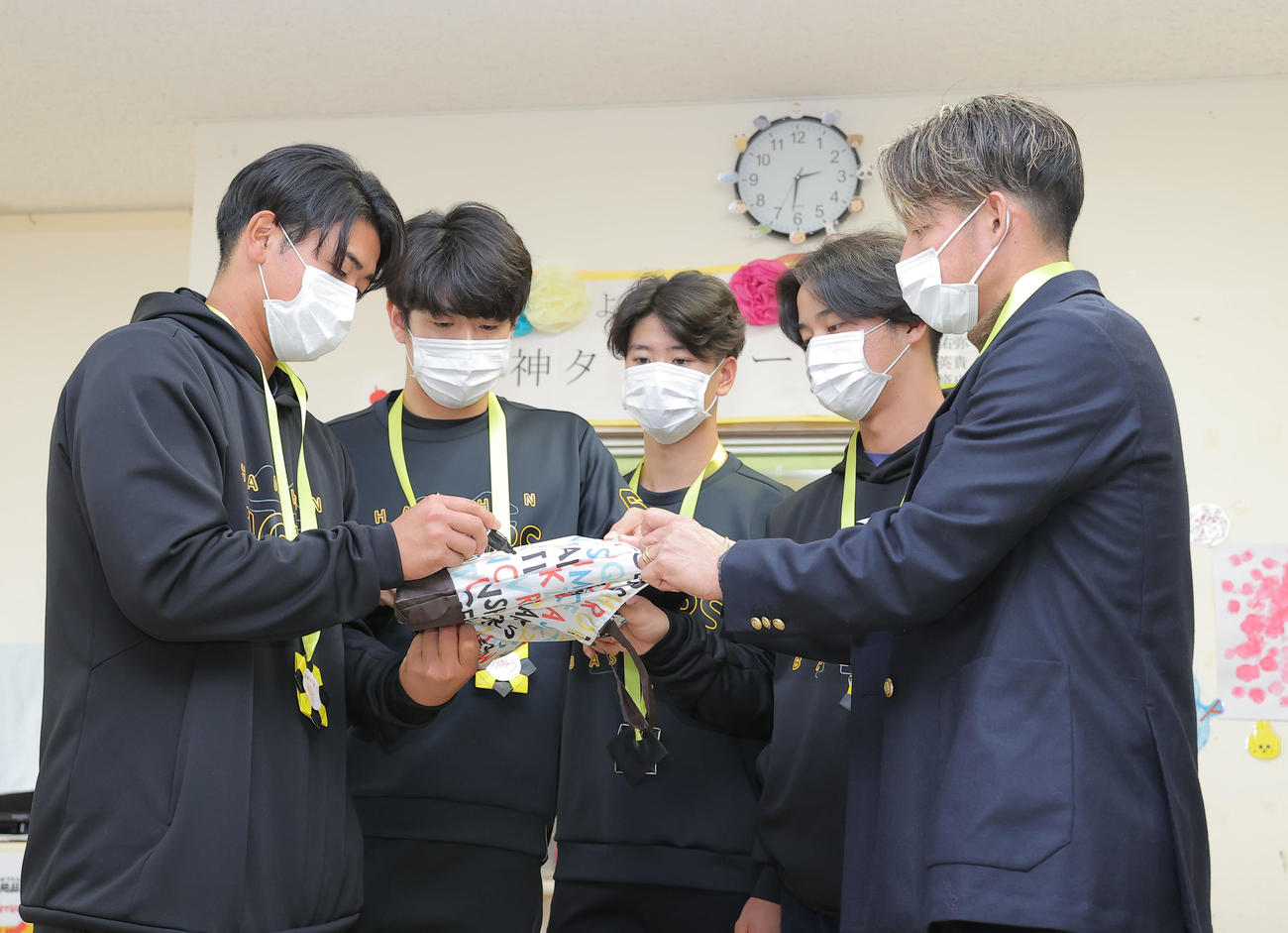 沖縄県立南部医療センター・こども医療センターを訪問し、グッズにサインをする左から阪神岡留、石黒、山田、井坪、鳥谷敬氏