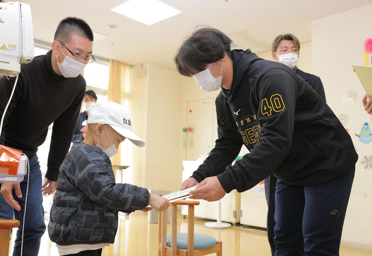 沖縄県立南部医療センター・こども医療センターを訪問し、子どもたちと触れ合う阪神井坪らら