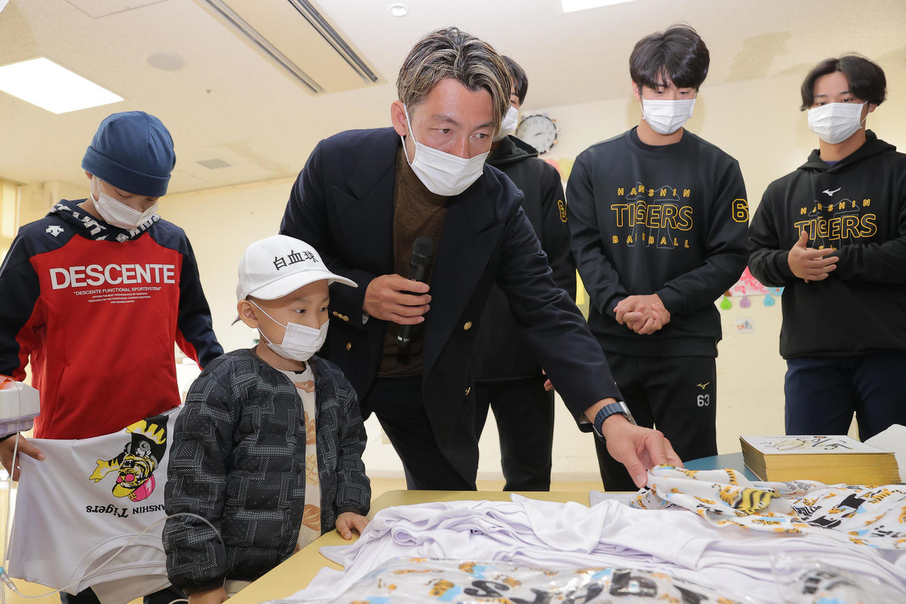 沖縄県立南部医療センター・こども医療センターを訪問し、子どもたちと触れ合う鳥谷敬氏（中央）。右から阪神井坪、石黒