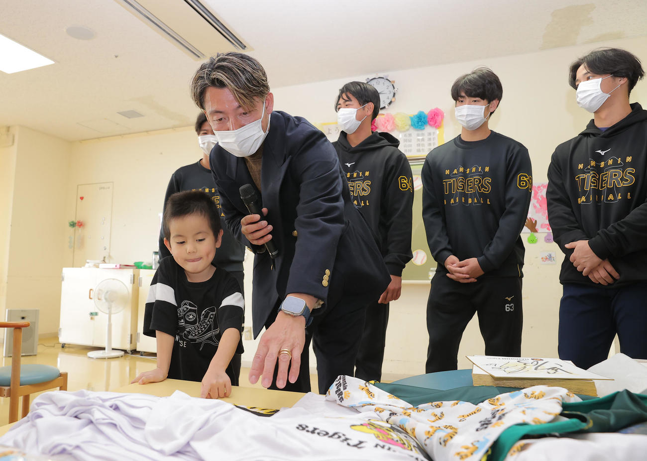 沖縄県立南部医療センター・こども医療センターを訪問し、子どもたちと触れ合う鳥谷敬氏（左から2人目）。右から阪神井坪、石黒、岡留