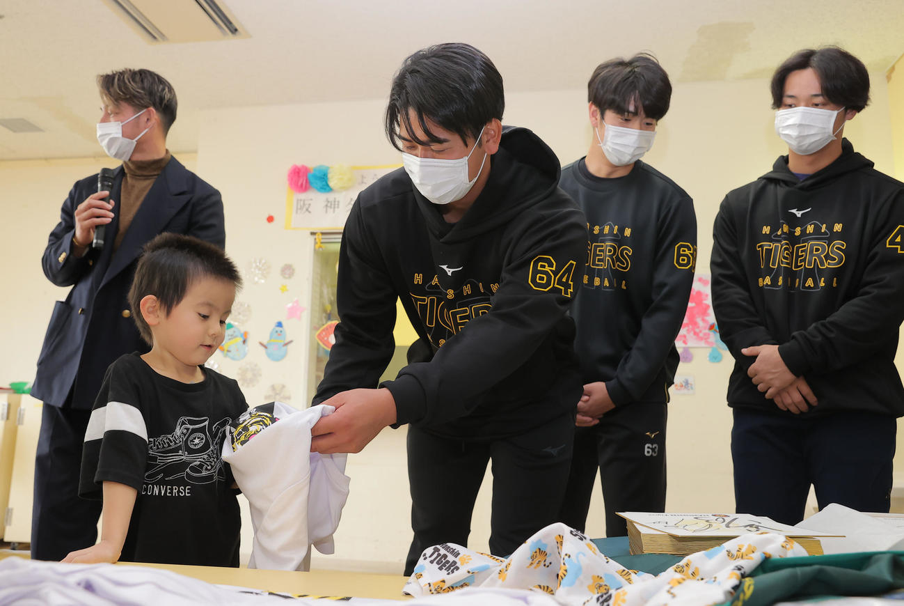 沖縄県立南部医療センター・こども医療センターを訪問し、子どもたちと触れ合う阪神岡留（中央）ら