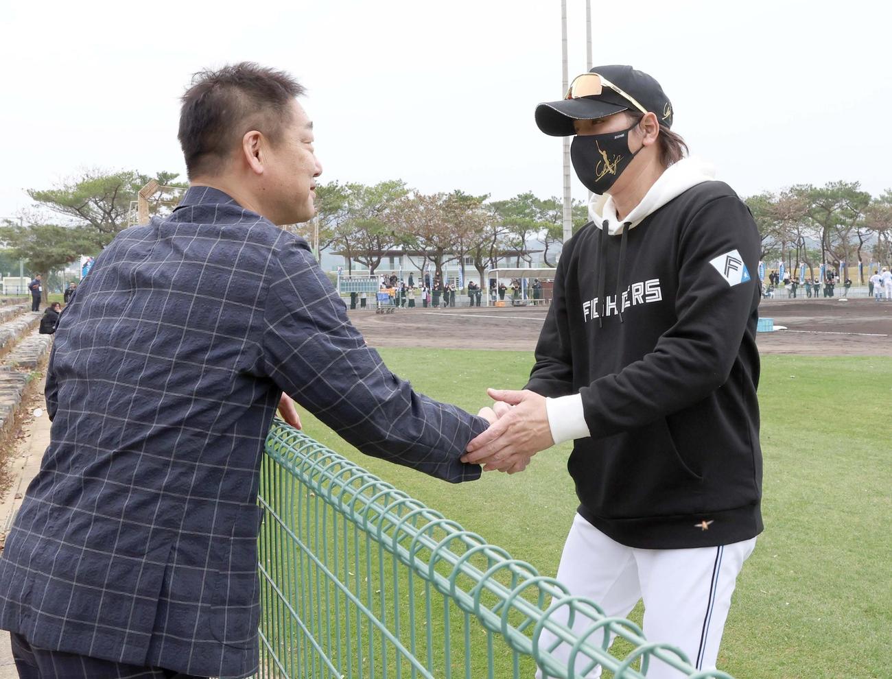 日本ハムのキャンプ地を訪れたオリックス中嶋SA（左）と握手する新庄監督（撮影・黒川智章）
