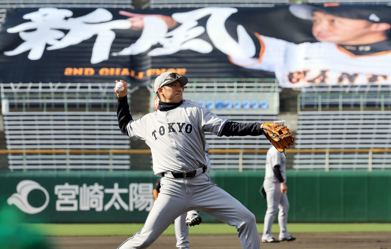 キャンプ5日目、巨人阿部慎之助監督の「新風」の横断幕を背にキャッチボールする坂本（撮影・浅見桂子）