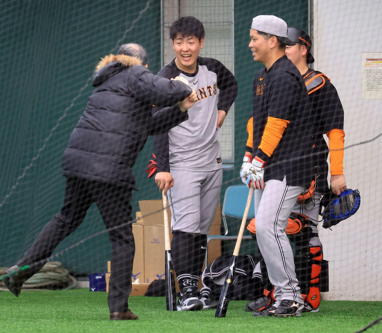 キャンプ5日目、練習後、村田真一氏（手前左）らと談笑する巨人岡本（中央）（撮影・浅見桂子）