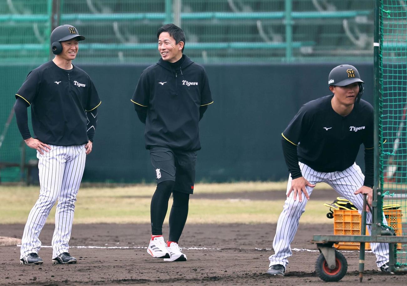 赤星氏（中央）は近本と談笑する。一塁走者は森下（撮影・上田博志）