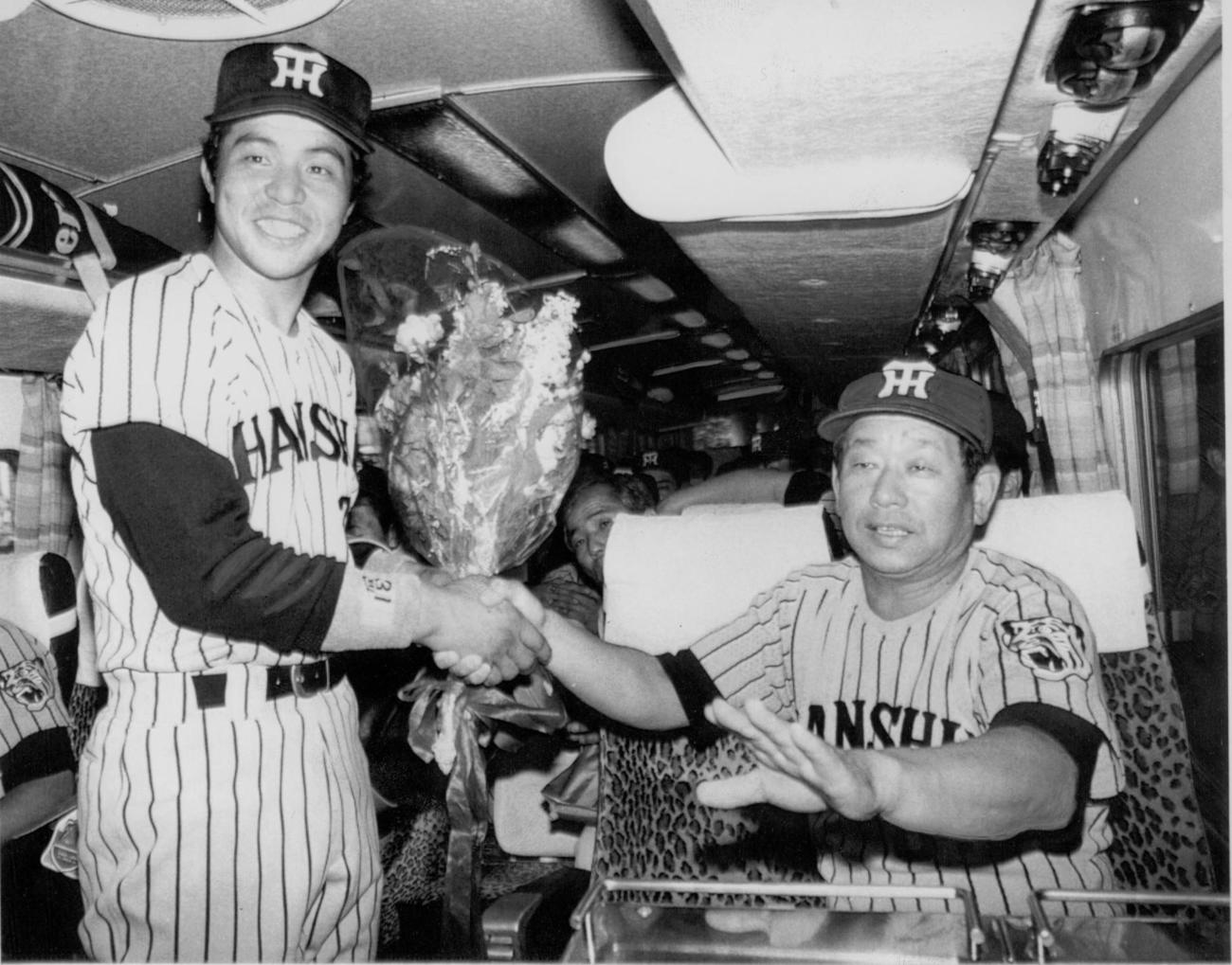 1985年6月、プロ通算300号本塁打達成した掛布雅之（左）は、帰路につくバスの中で吉田義男監督と握手を交わす