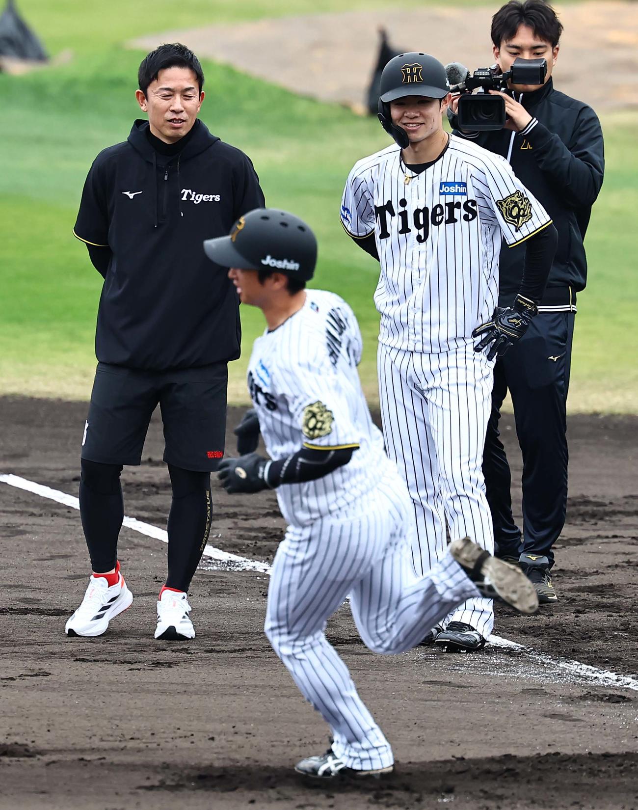 赤星氏（左）は中野と話をする。手前は走塁練習をする近本（撮影・上田博志）