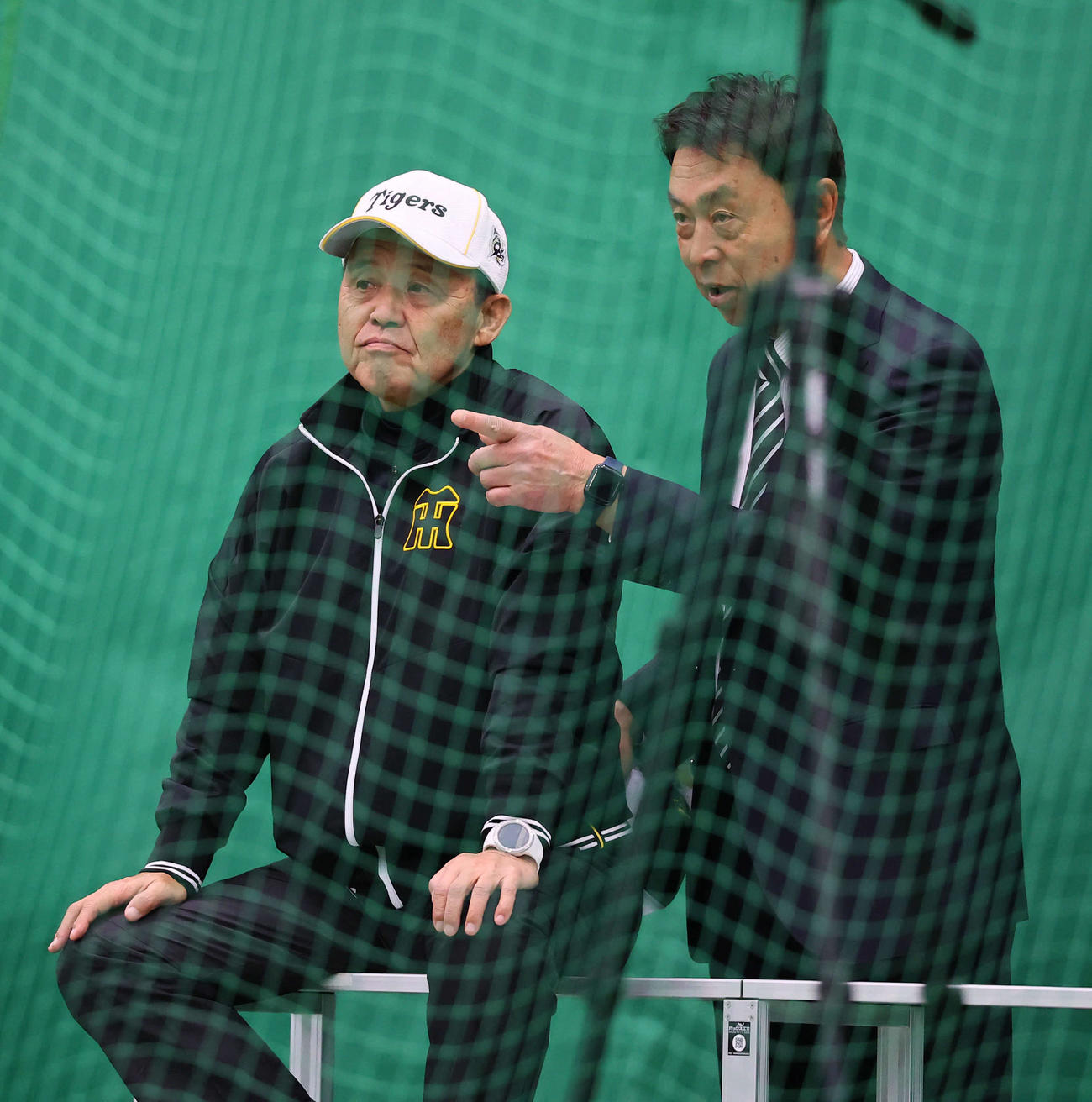 ブルペンで練習を見守る阪神岡田オーナー付顧問（左）。右はヤクルト小川GM（撮影・藤尾明華）