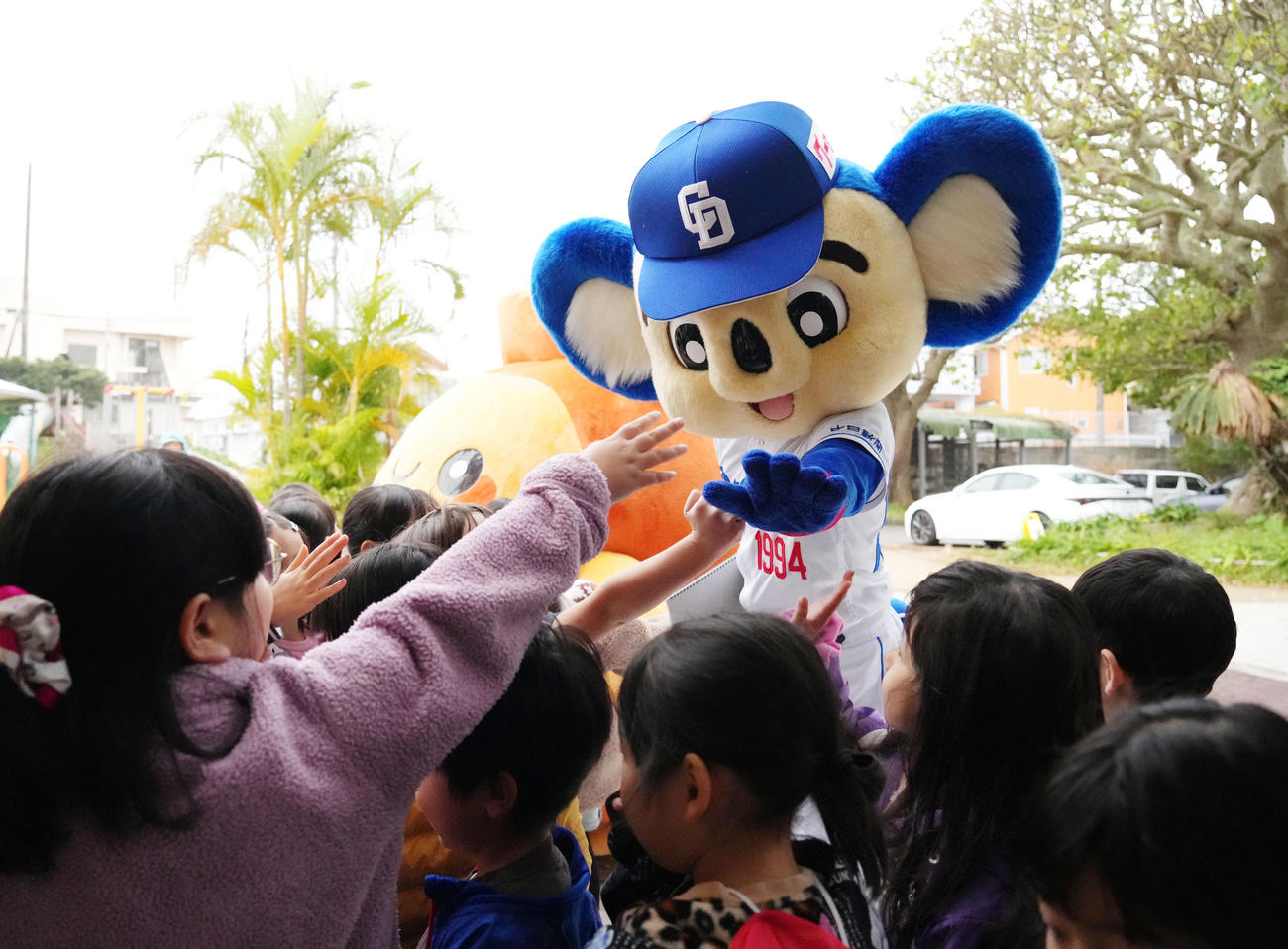 毎年恒例のあいさつ運動行い隣接する幼稚園で園児とタッチを交わすドアラ（撮影・森本幸一）