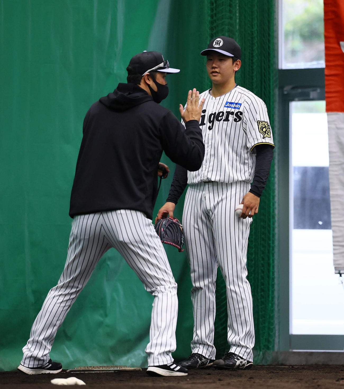 ブルペンで金村投手コーチ（左）の指導を受ける門別（撮影・藤尾明華）