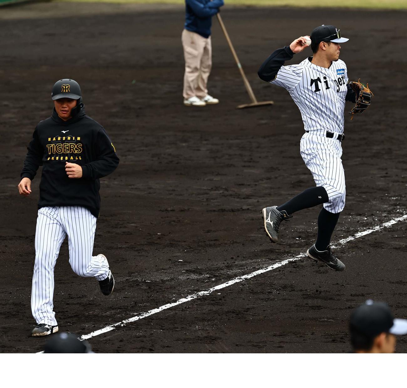 挟殺プレーの練習をする佐藤輝（右）は森下にタッチ後、二塁へジャンピングスローする（撮影・上田博志）