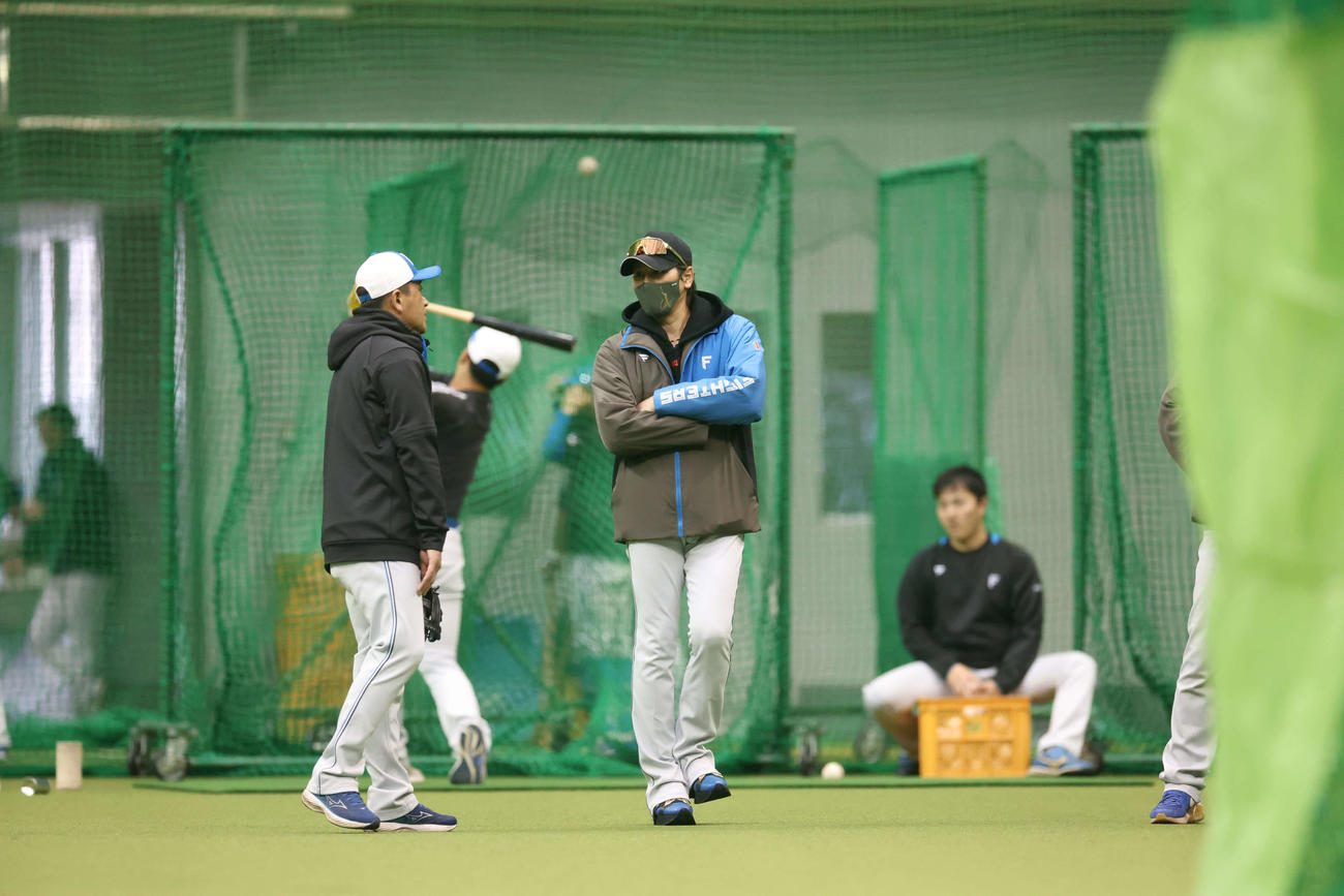 室内練習場で日本ハム林ヘッドコーチと話しをする新庄監督（右）（撮影・黒川智章）