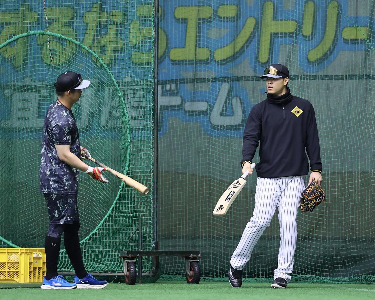 クリケットバットを手に、話をする佐藤輝（右）野口（撮影・藤尾明華）
