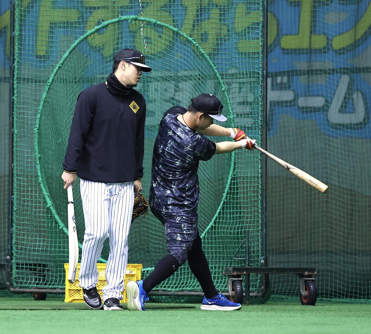 クリケットバットを手に、話をする佐藤輝（左）野口（撮影・藤尾明華）