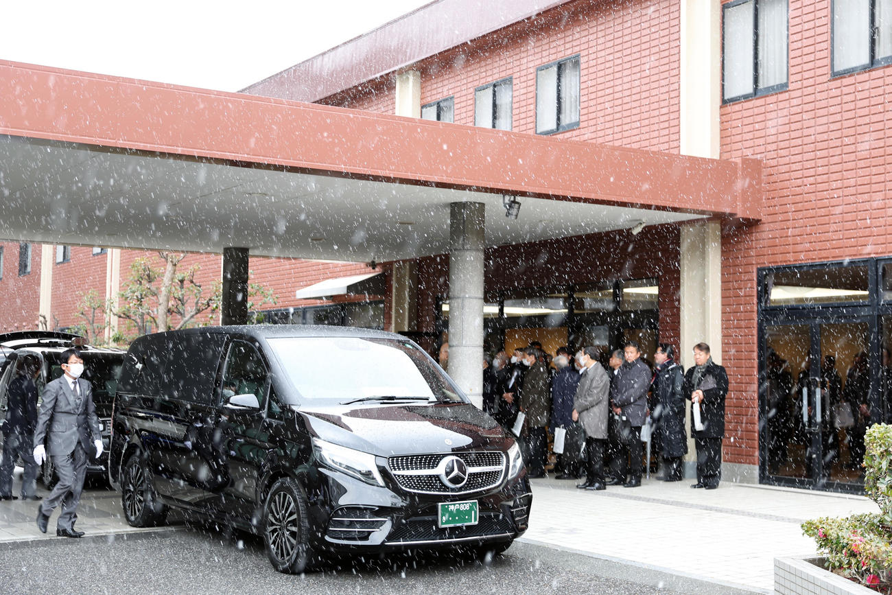 雪が舞う中、葬儀場を出る吉田義男さんの棺を乗せた霊きゅう車（撮影・前田充）