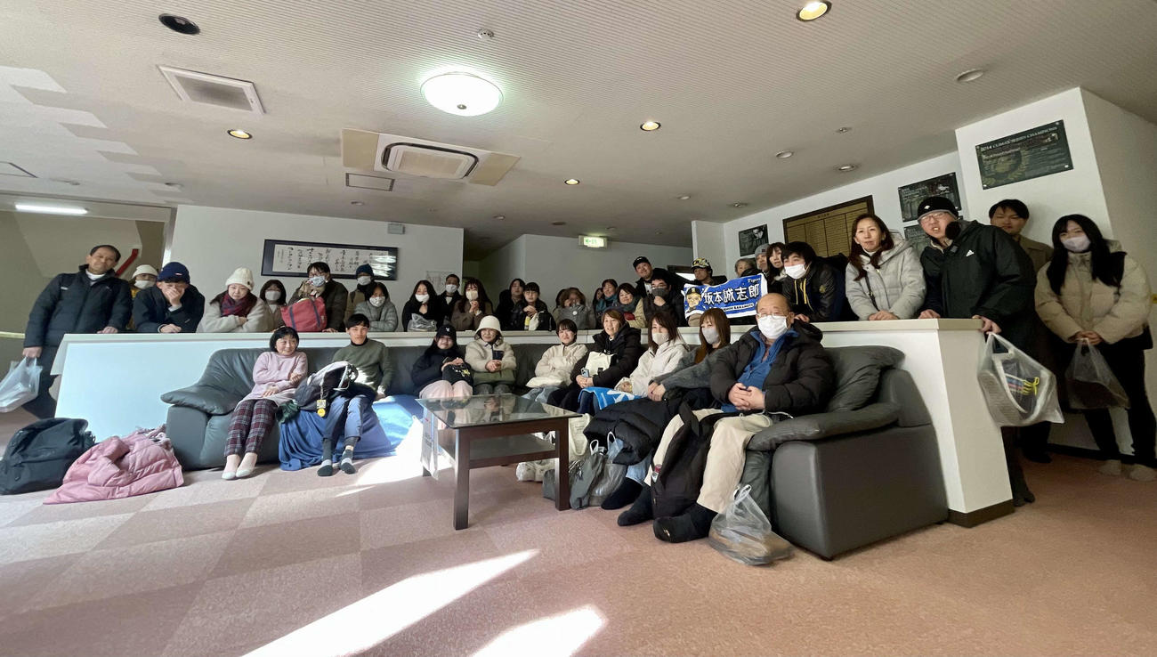 1月末まで約30年使われた阪神選手寮・虎風荘のリビングのテレビで紅白戦を観戦する、約40名のファンたち（撮影・中島麗）