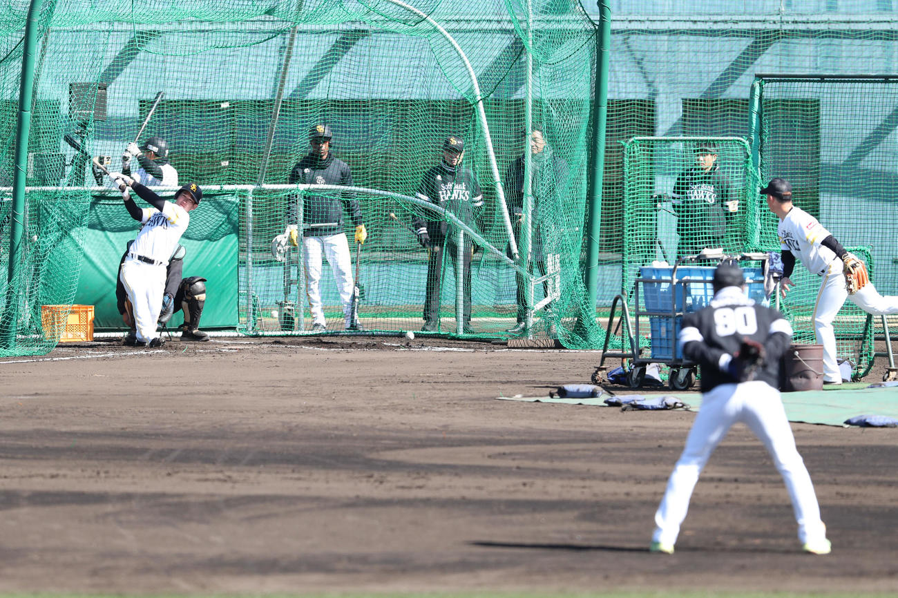 打撃練習をする栗原、手前は見守る小久保監督（撮影・梅根麻紀）