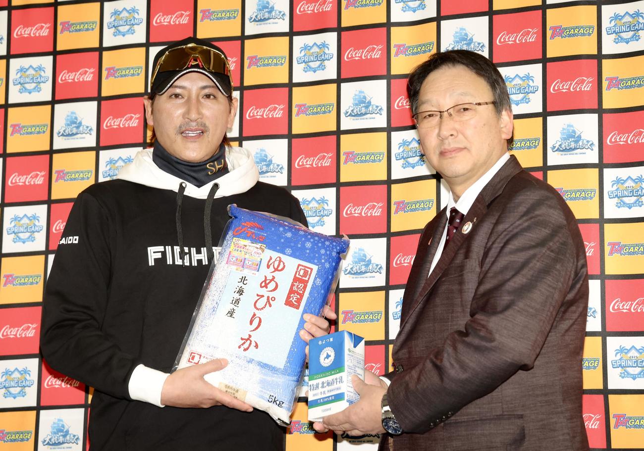 ホクレン農業協同組合連合会徳田代表理事副会長（右）から北海道米ゆめぴりかと北海道産牛乳を贈呈され、写真に納まる日本ハム新庄監督（撮影・河田真司）