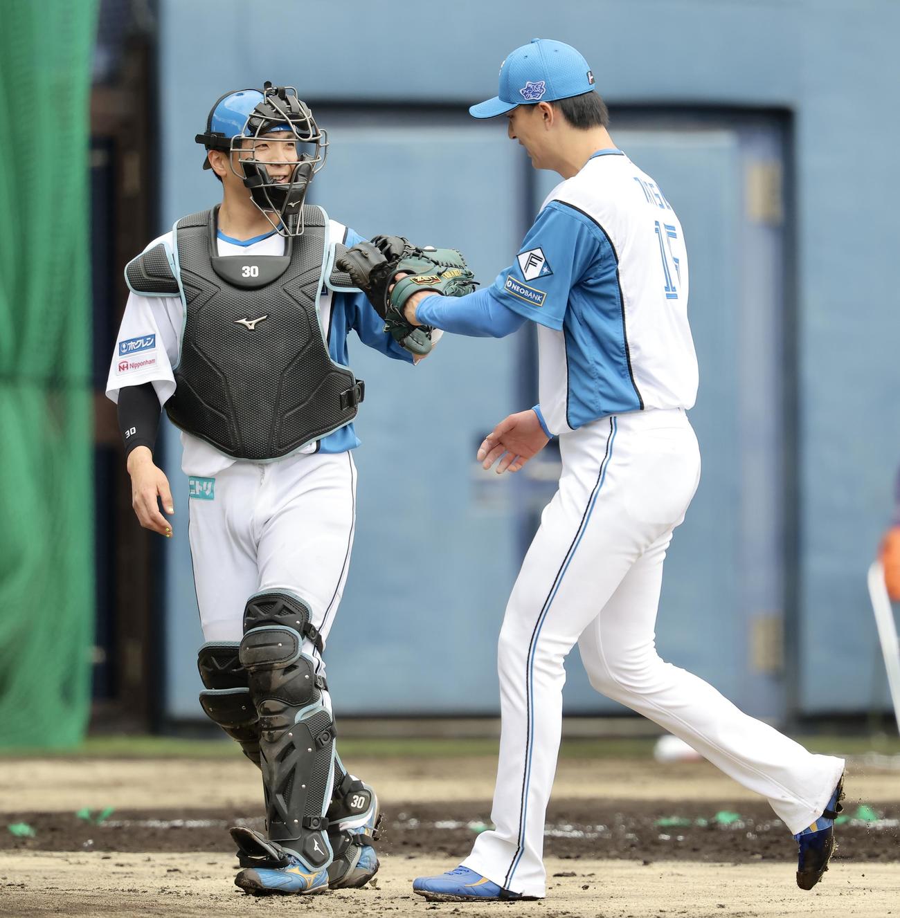 1回表を終え、グラブタッチを交わす日本ハム郡司（左）と達（撮影・河田真司）