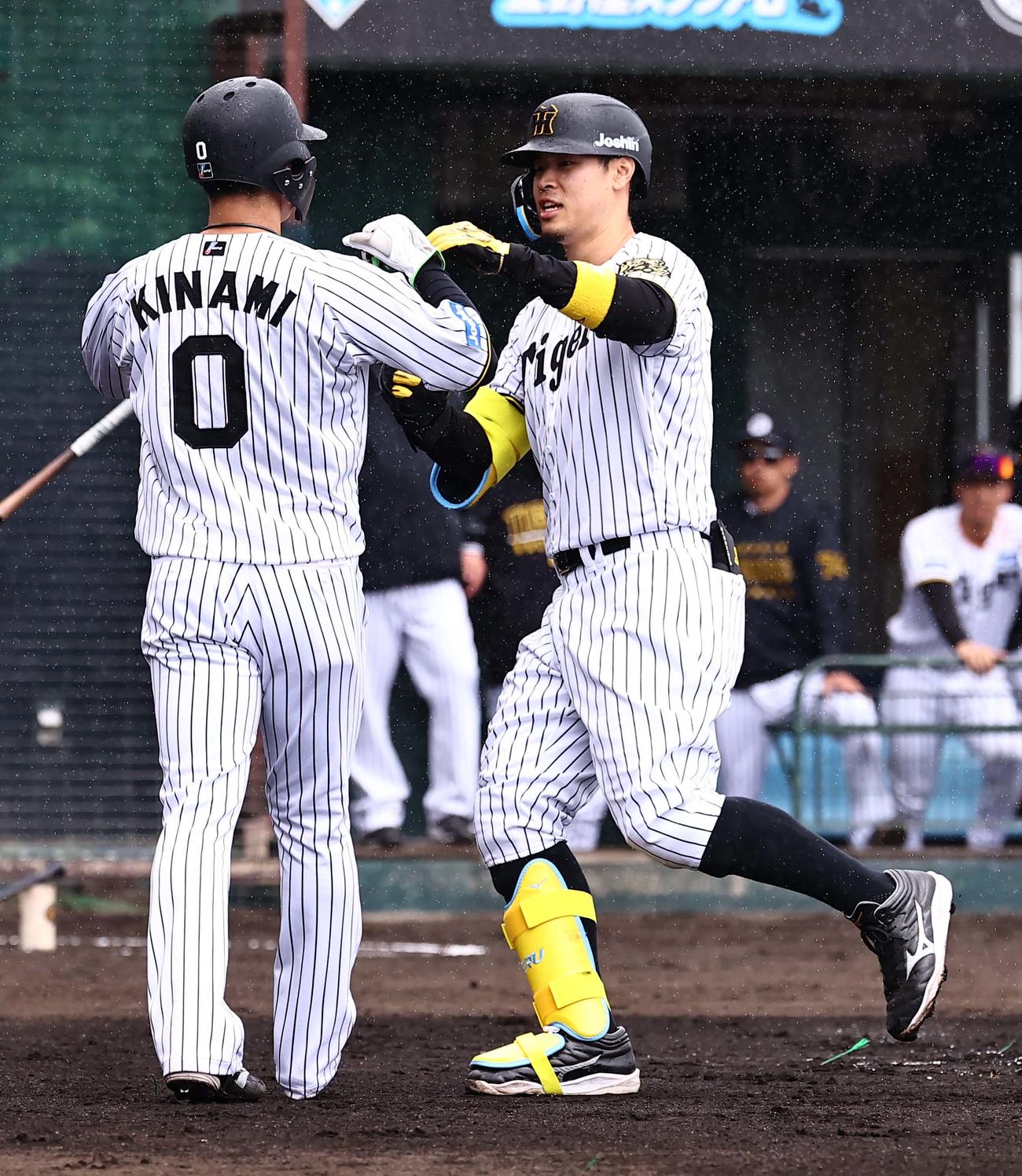 紅白戦　1回裏白組1死一塁、右越え2点本塁打を放った佐藤輝（右）は木浪の出迎えを受ける（撮影・上田博志）