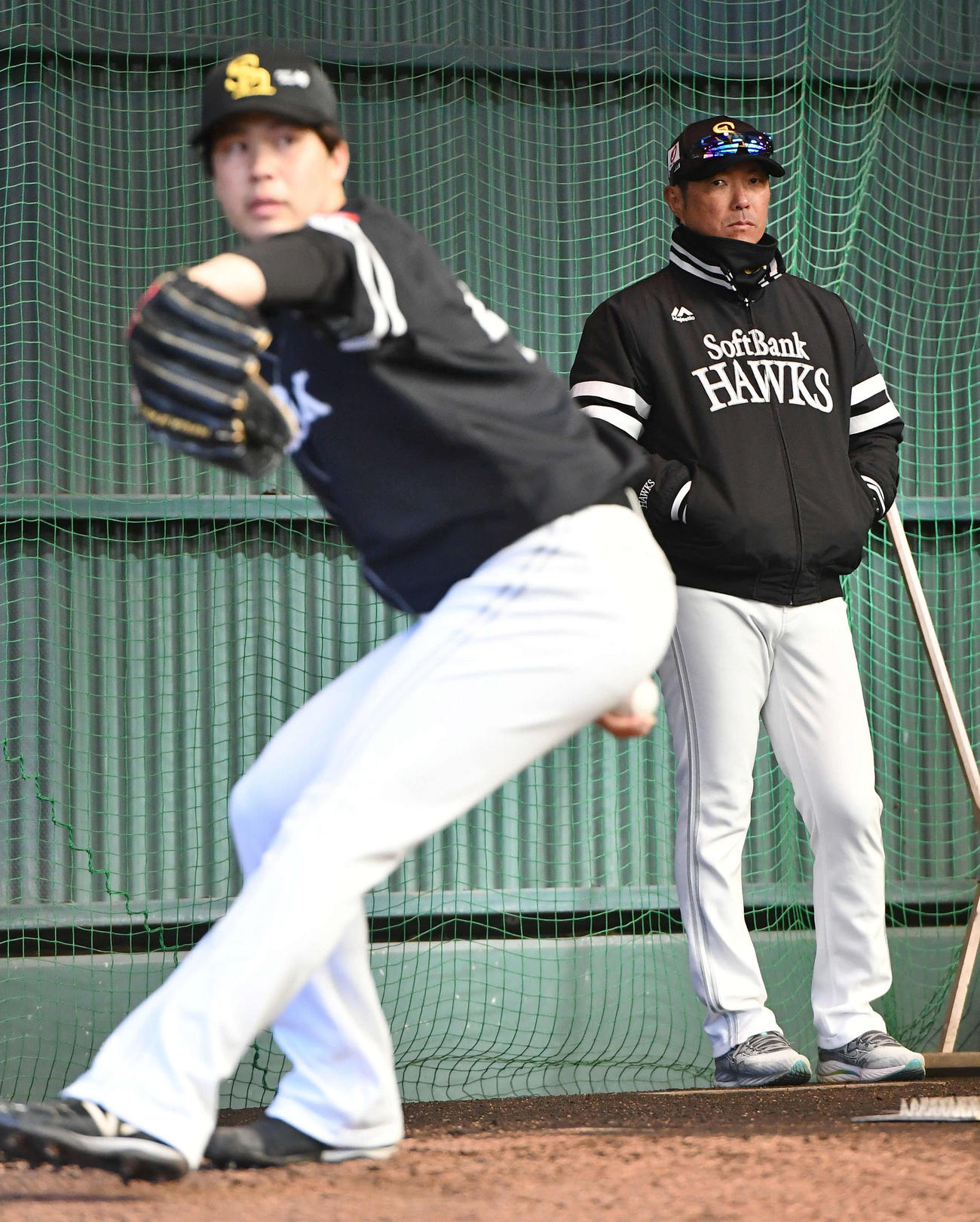 ブルペンで投げ込む藤井（左）を見つめるソフトバンク小久保監督（撮影・岩下翔太）