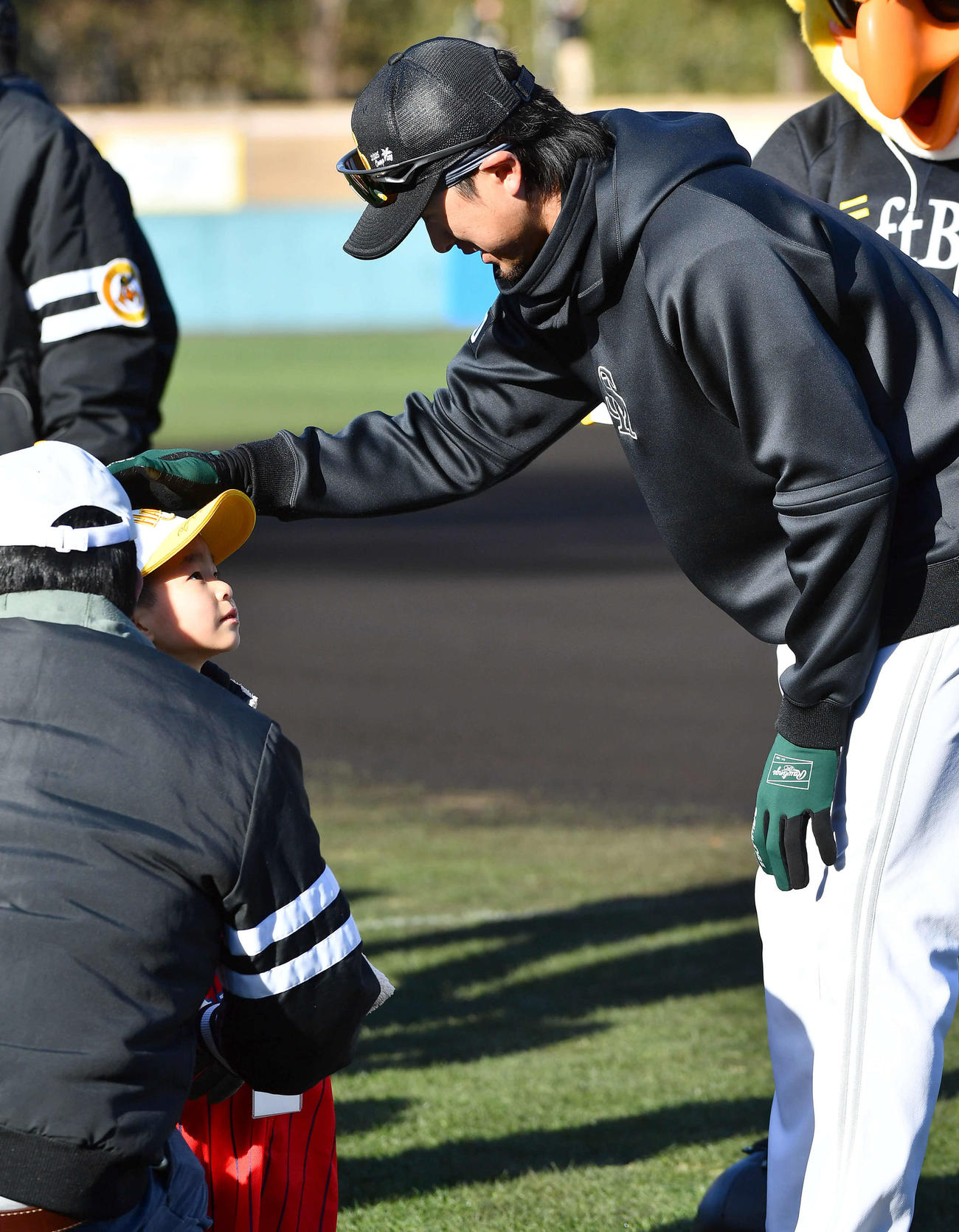 ファンの子どもにサイン入りの帽子をかぶせて頭をなでるソフトバンク上沢（撮影・岩下翔太）