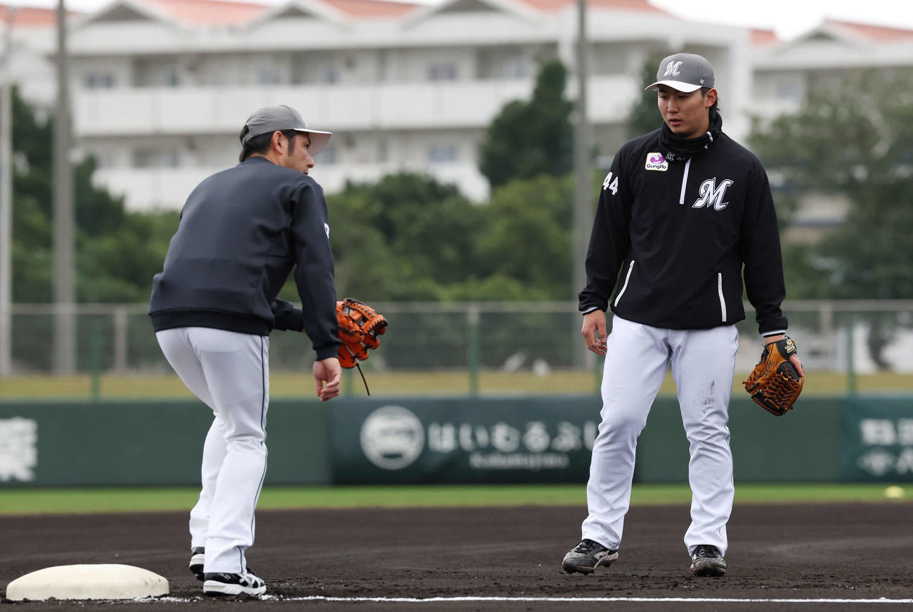 ロッテ根元内野守備兼走塁コーチ（左）から指導を受ける宮崎（撮影・宮地輝）