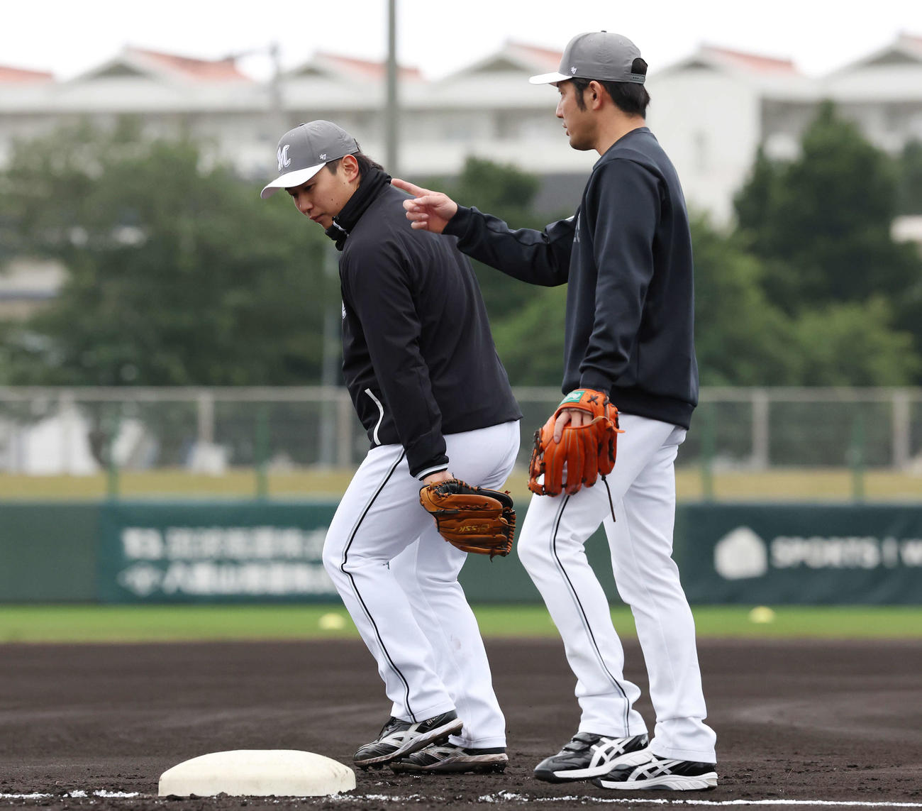 ロッテ根元内野守備兼走塁コーチ（右）から指導を受ける宮崎（撮影・宮地輝）