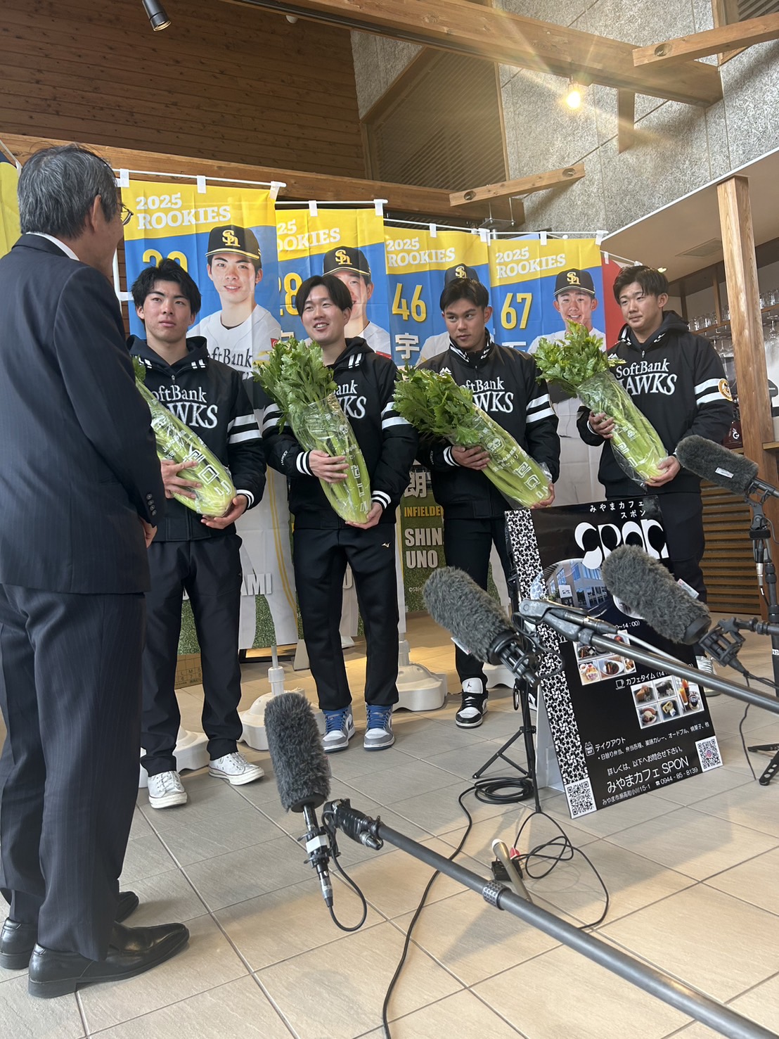 セロリを手に、福岡・みやま市の松嶋市長（手前）の話を聞くソフトバンクの新人4選手たち。左から村上、安徳、宇野、石見（撮影・佐藤究）