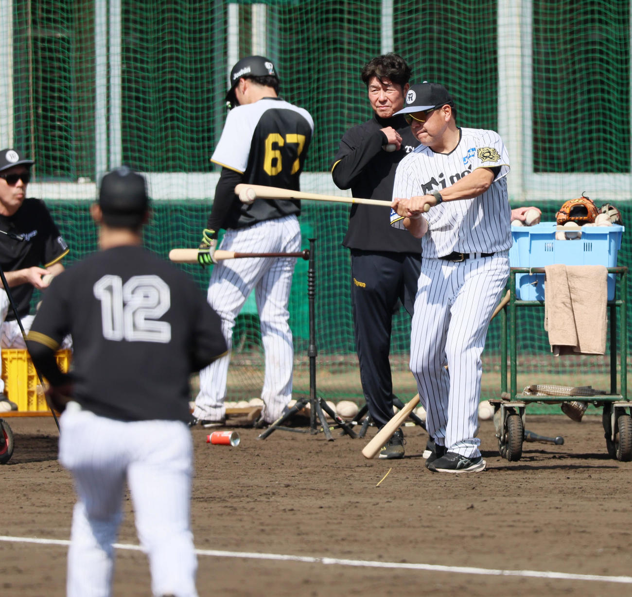 2日、坂本（左）ら捕手陣にノックを打つ阪神野村コーチ（撮影・加藤哉）