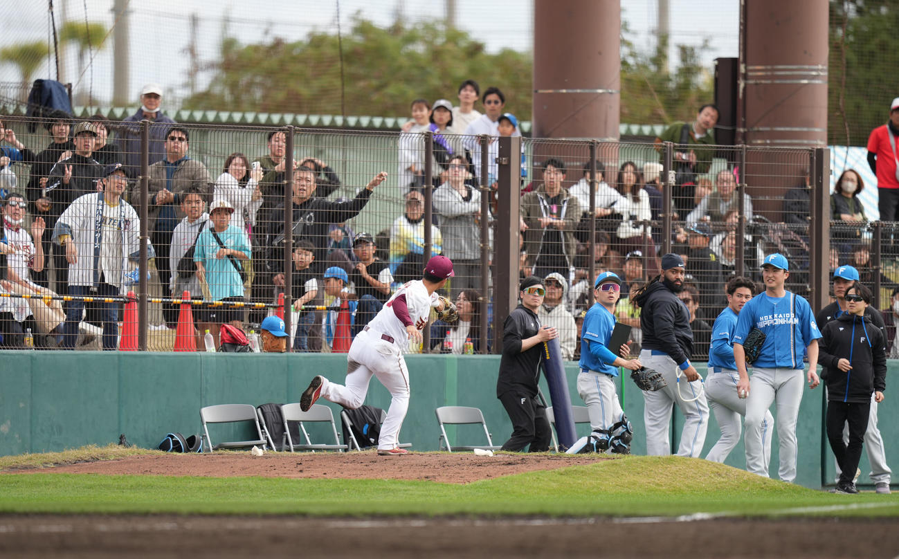 楽天対日本ハム　3回表日本ハム無死一、二塁、奈良間の飛球を追って、相手ブルペンでグラブを伸ばす遊撃手宗山（撮影・鈴木みどり）