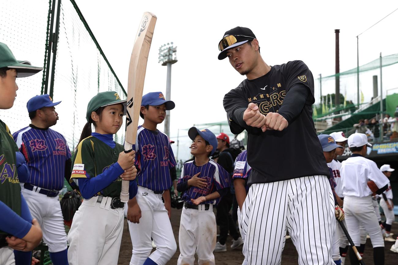 野球教室でクリケットバットを使って子どもたちを指導する阪神佐藤輝（右）（撮影・前田充）