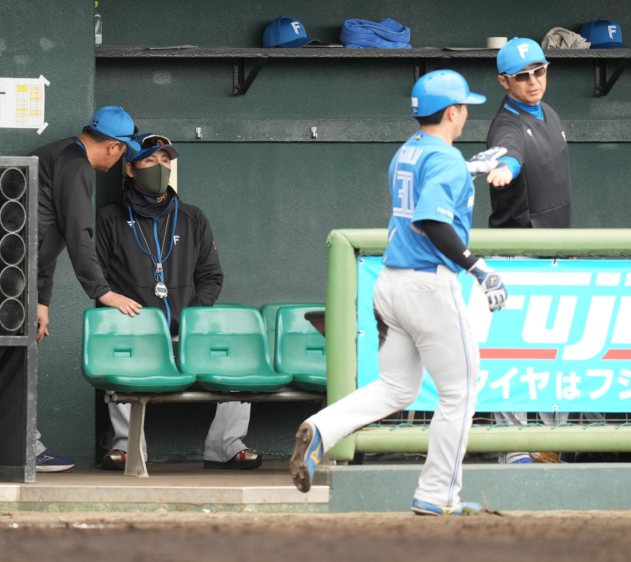 楽天対日本ハム　2回表日本ハム1死二塁、水野の先制の中前適時打で生還し、ナインとハイタッチする二塁走者郡司（右から2人目）。左から2人目は新庄監督（撮影・鈴木みどり）
