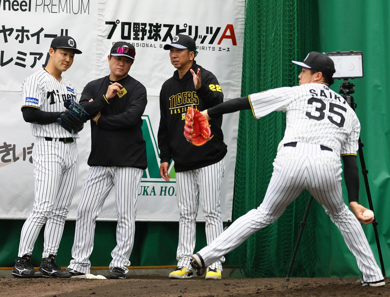 ブルペンで才木（手前）の投球練習を見ながら藤川監督（奥右）に指導を受ける木下（左端）（撮影・藤尾明華）